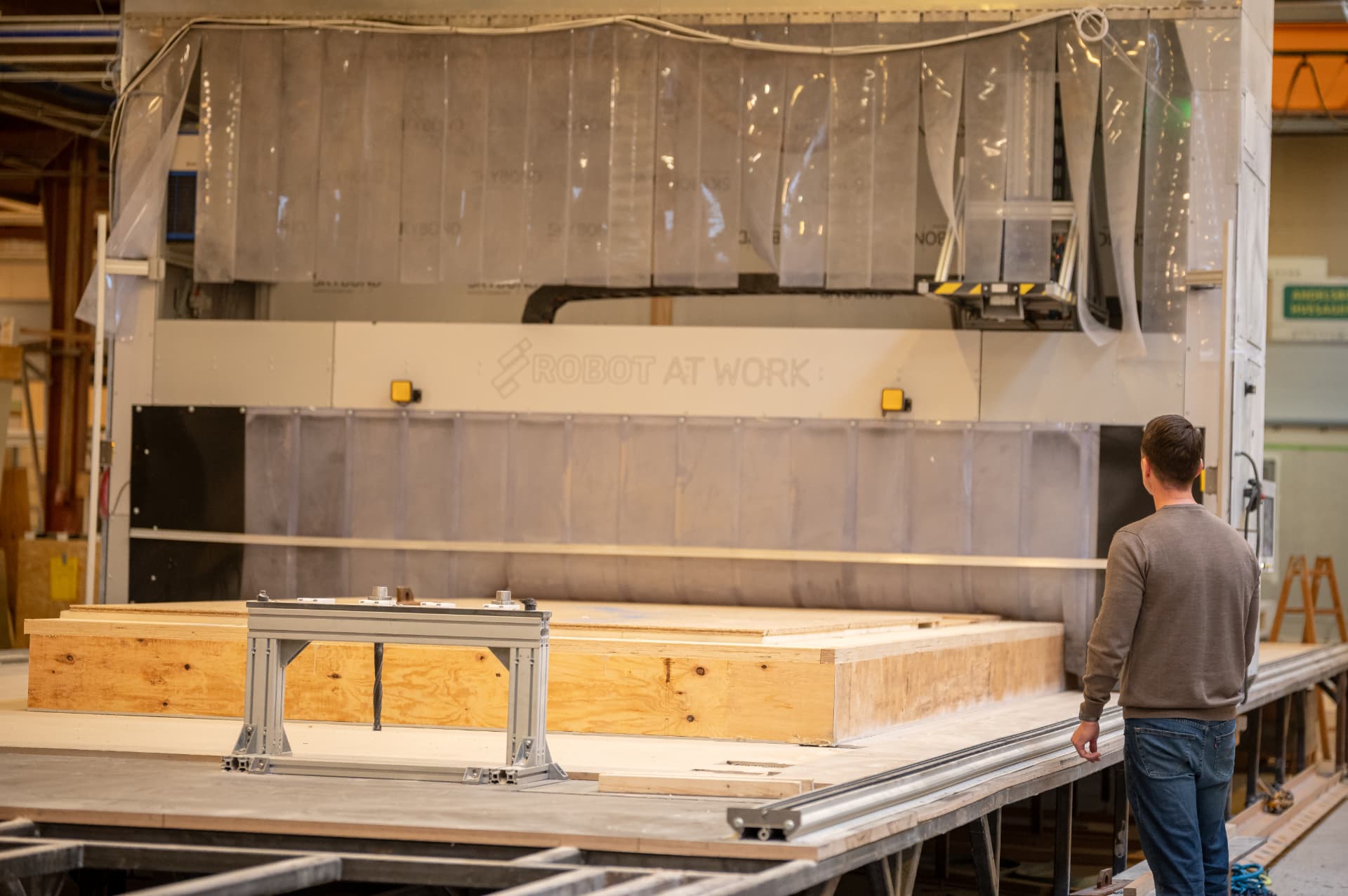 Employee at the gantry system with a large timber element ready for machining