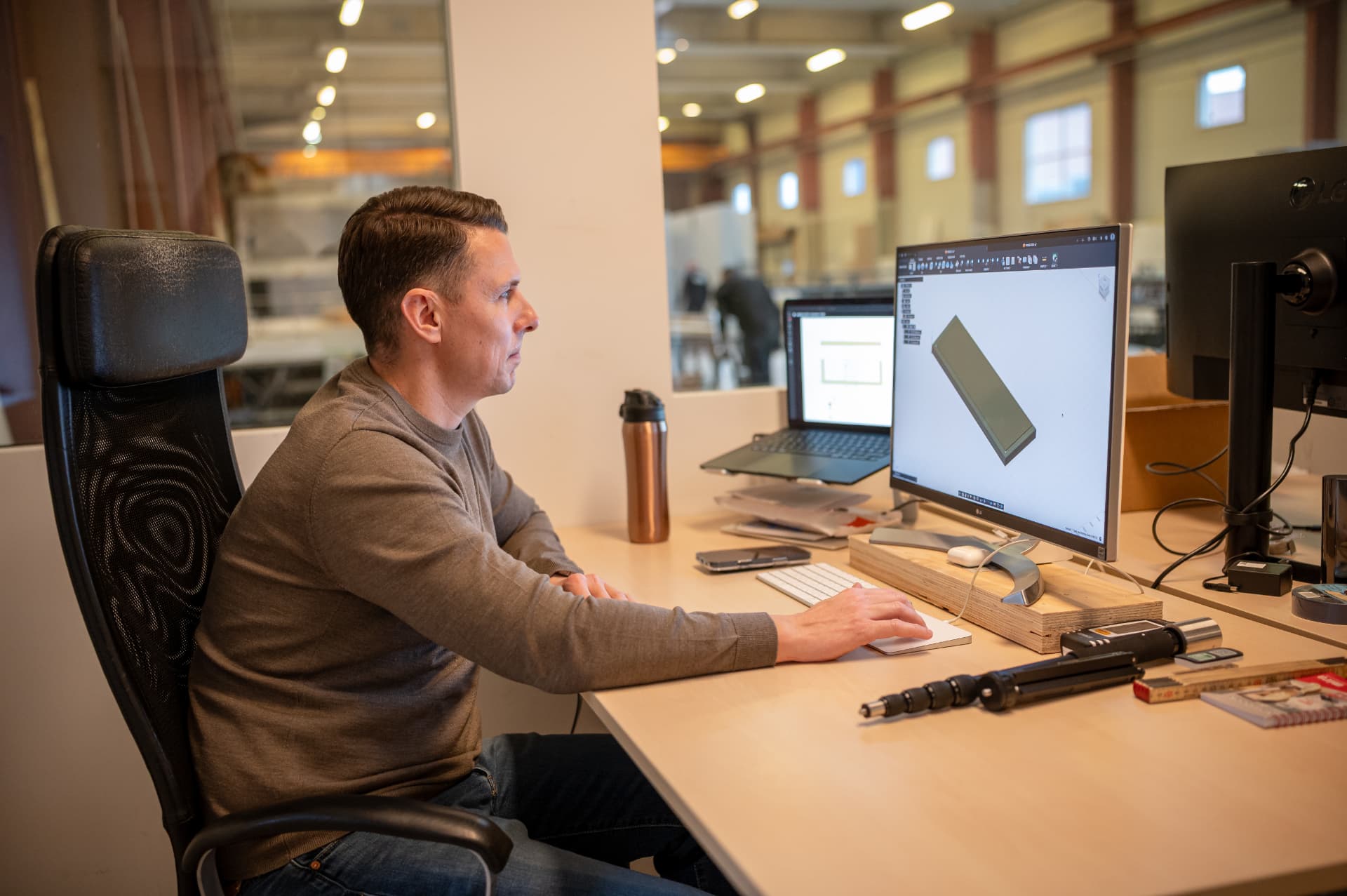 Employee working with a 3D model of a timber element on a screen in the office