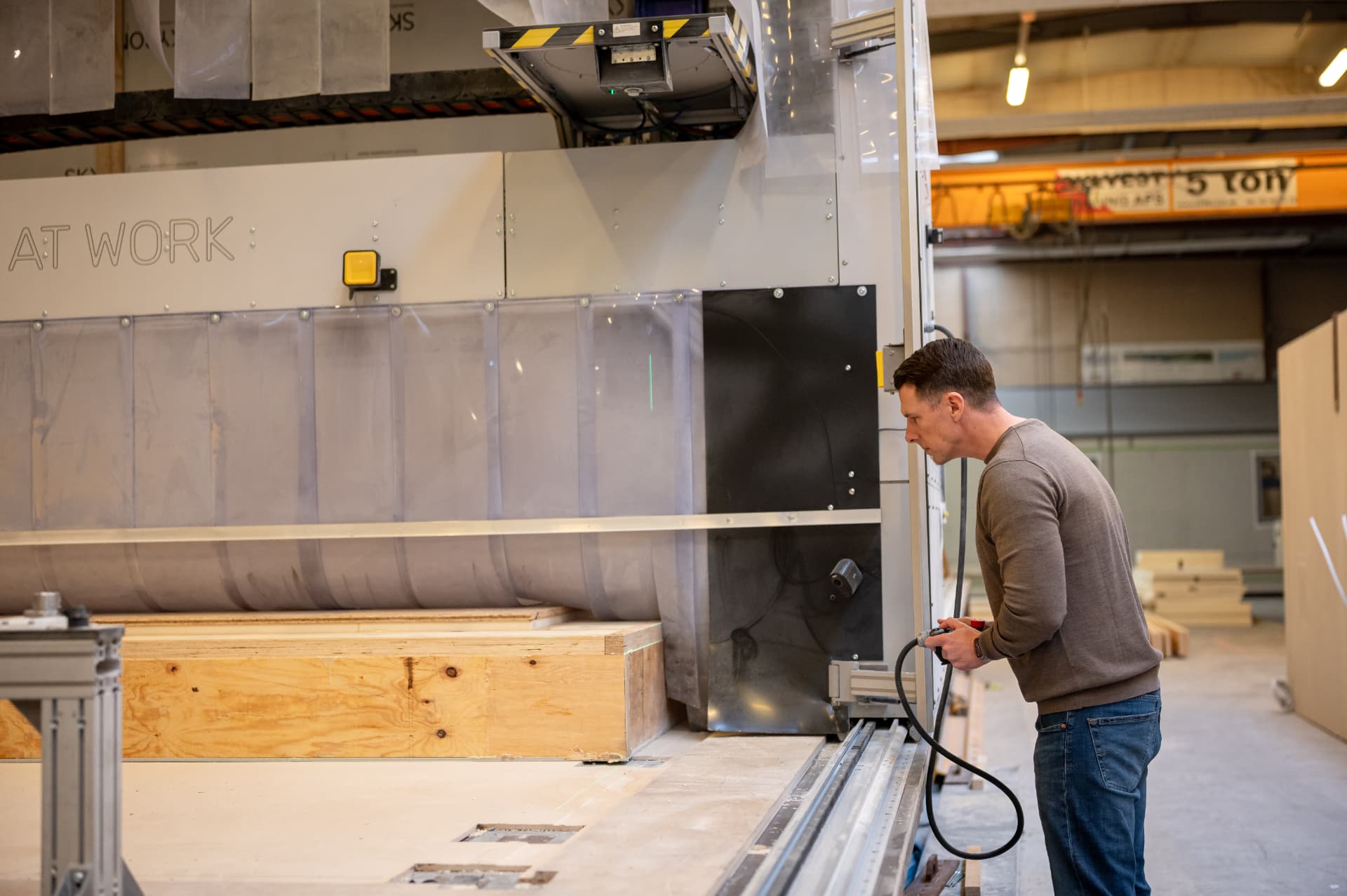 Operator closely monitoring the machining process at the side of the system